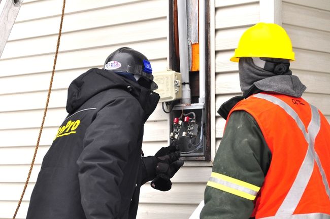 Des travailleurs installent un compteur intelligent d'Hydro-Québec. La Ville de Laval dénonce les situations &quot;d'intimidation&quot; dont ont fait face certains Lavallois lorsqu'ils ont refusé qu'on installe un nouveau compteur dans leur demeure.