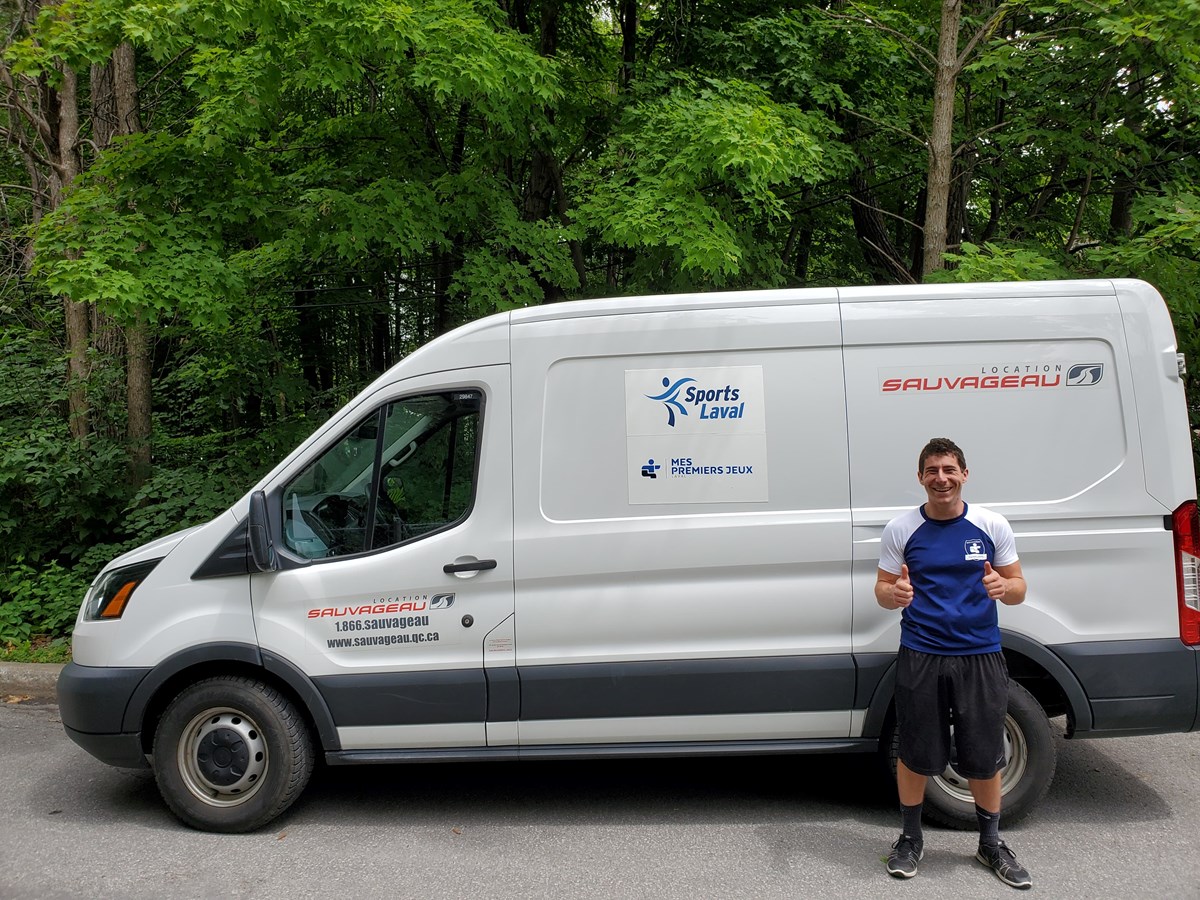 Francis Bissonnette, chargé de projet à Sports Laval, devant la Caravane "Mes premiers jeux", qui sillonnera 22 sites de camps de la ville cet été.