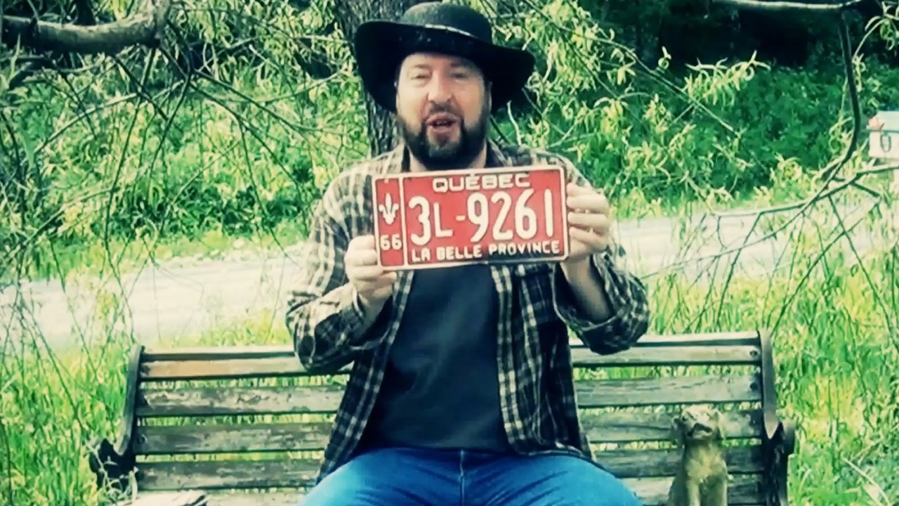 Normand DeLessard présente un souvenir des anciennes plaques d'immatriculation